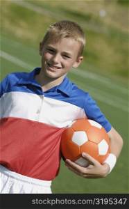 Portrait of a soccer player holding a soccer ball and smiling