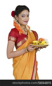 Portrait of a South Indian woman holding a thali