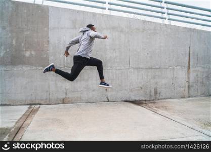 Portrait of a sport man jumping and doing exercise outdoors. Sport, fitness and healthy lifestyle.