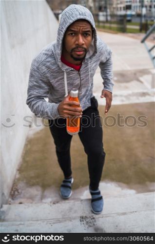 Portrait of a sport man running up on stairs outdoors. Fitness, sport and healthy lifestyle concepts.