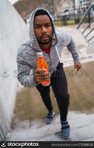 Portrait of a sport man running up on stairs outdoors. Fitness, sport and healthy lifestyle concepts.