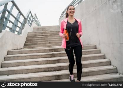 Portrait of a sport woman running on stairs outdoors. Fitness, sport and healthy lifestyle concepts.