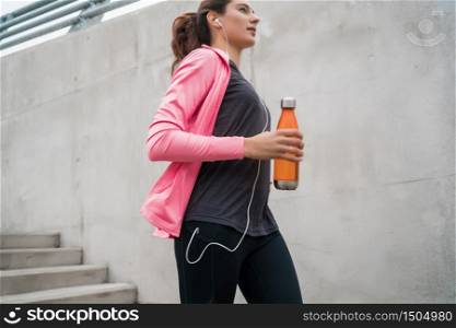 Portrait of a sport woman running on stairs outdoors. Fitness, sport and healthy lifestyle concepts.