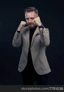 Portrait of a stylish elegant senior businessman with a beard and casual business clothes ready to fight hands gesture