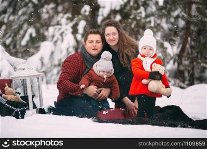 portrait of a stylish family having a good time in the winter forest. decorated place to relax. portrait of a stylish family having a good time in the winter forest. decorated place to relax.