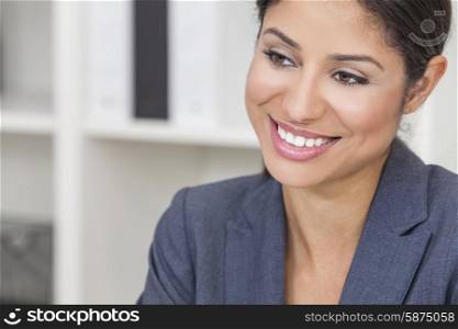 Portrait of a successful beautiful young Latina Hispanic woman or businesswoman in her office smiling with perfect teeth
