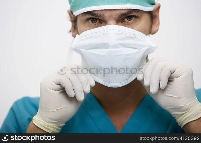 Portrait of a surgeon adjusting a surgical mask