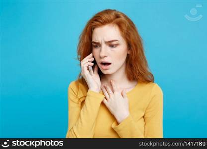 Portrait of a surprised confused woman in yellow casual calling mobile phone isolated over blue background