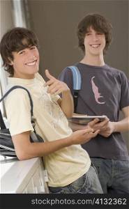 Portrait of a teenage boy and a young man smiling together