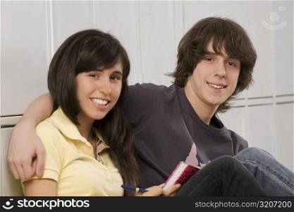 Portrait of a teenage boy arm around with a teenage girl and smiling