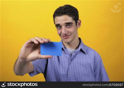 Portrait of a teenage boy holding a card
