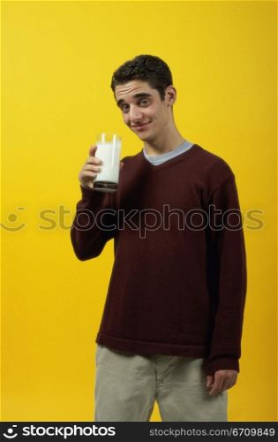 Portrait of a teenage boy holding a glass of milk