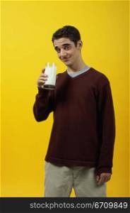 Portrait of a teenage boy holding a glass of milk