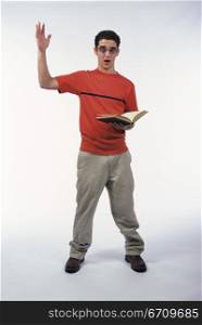 Portrait of a teenage boy raising his hand