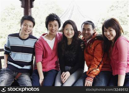 Portrait of a teenage boy sitting together with his friends smiling
