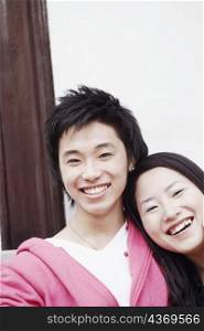 Portrait of a teenage boy smiling with a young woman