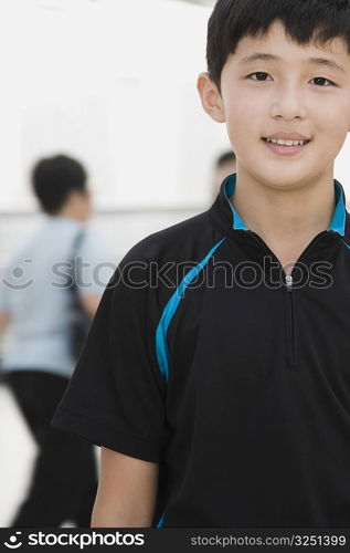 Portrait of a teenage boy standing in a corridor and smiling