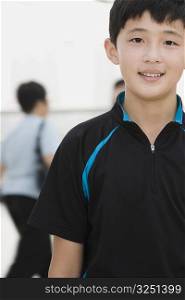 Portrait of a teenage boy standing in a corridor and smiling