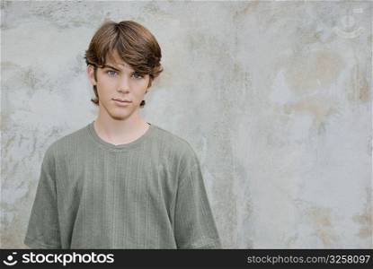 Portrait of a teenage boy standing in front of a wall