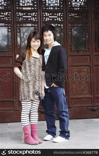 Portrait of a teenage boy standing with a young woman