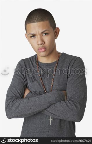 Portrait of a teenage boy standing with his arms crossed