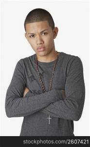 Portrait of a teenage boy standing with his arms crossed