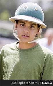 Portrait of a teenage boy wearing a polo helmet