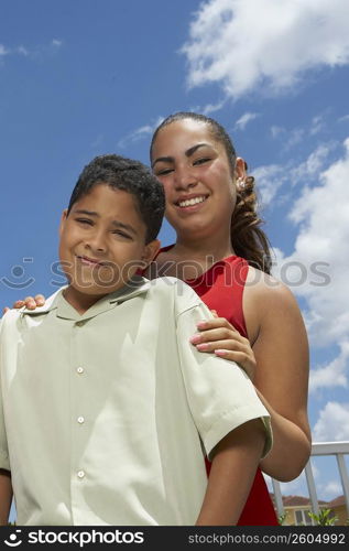 Portrait of a teenage girl and her brother smiling