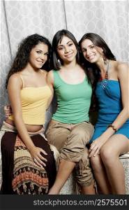 Portrait of a teenage girl and two young women sitting side by side