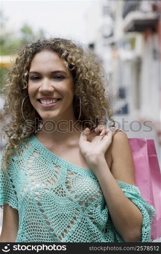 Portrait of a teenage girl carrying a shopping bag and smiling