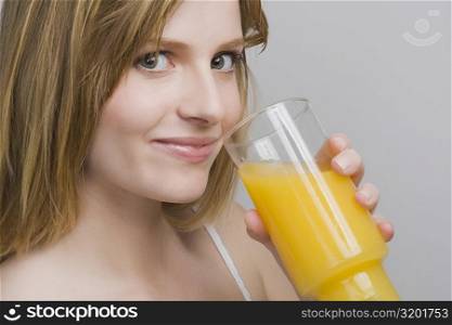 Portrait of a teenage girl drinking a glass of orange juice