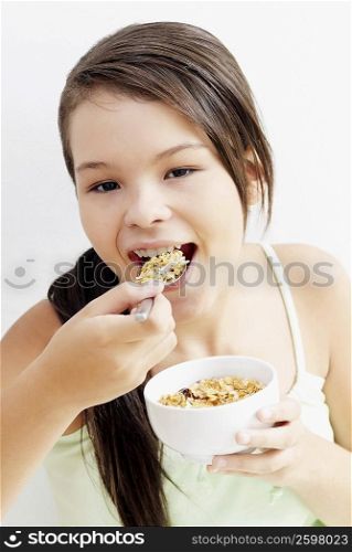 Portrait of a teenage girl eating a bowl of corn flakes