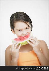 Portrait of a teenage girl eating a slice of watermelon