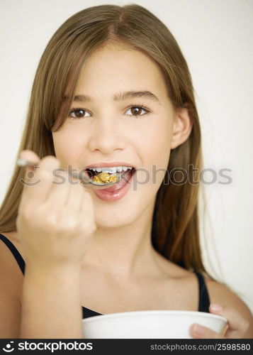 Portrait of a teenage girl eating cornflakes with a spoon