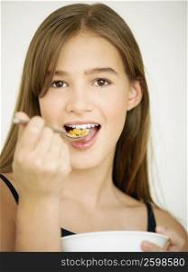 Portrait of a teenage girl eating cornflakes with a spoon