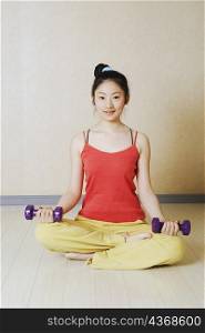 Portrait of a teenage girl exercising with dumbbells