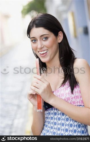 Portrait of a teenage girl holding a candy and smiling
