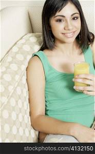 Portrait of a teenage girl holding a glass of orange juice
