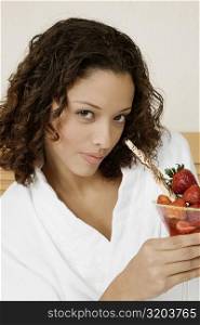 Portrait of a teenage girl holding a glass of strawberries