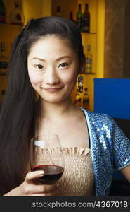 Portrait of a teenage girl holding a wineglass smiling