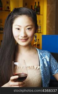 Portrait of a teenage girl holding a wineglass smiling
