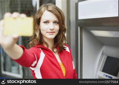 Portrait of a teenage girl holding an ATM card