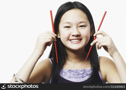 Portrait of a teenage girl holding chopsticks