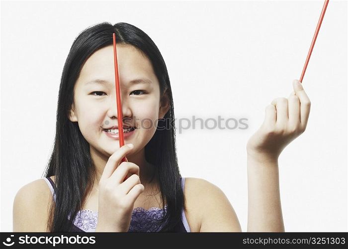 Portrait of a teenage girl holding chopsticks