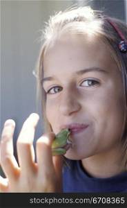 Portrait of a teenage girl kissing a frog