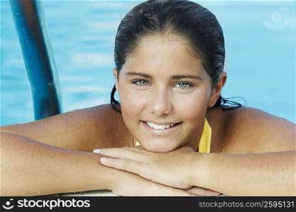 Portrait of a teenage girl leaning at the poolside