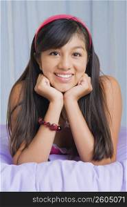 Portrait of a teenage girl lying on the bed and smiling