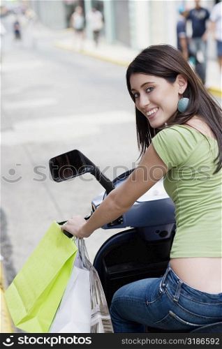 Portrait of a teenage girl riding on a scooter
