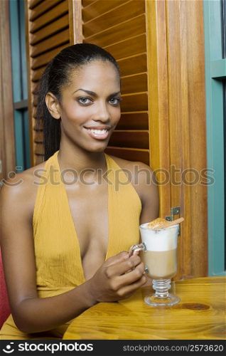 Portrait of a teenage girl sitting at a table with a cup of cappuccino