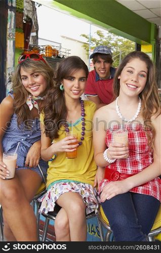 Portrait of a teenage girl sitting with her friends at a juice bar
